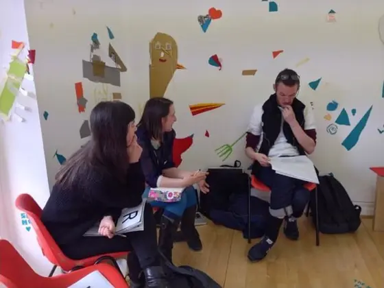 Three participants in conversation in a gallery space during the Modern Edinburgh Film School programme